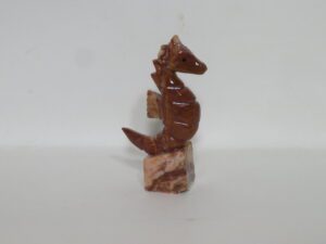 Carved brown stone seahorse figurine on base